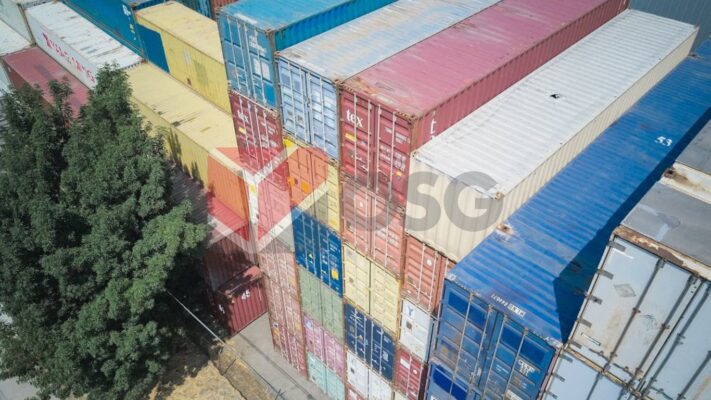Colorful shipping containers stacked in a warehouse setting.