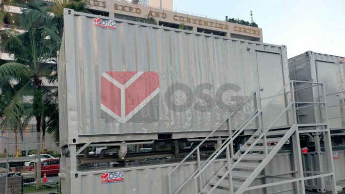 Metal shipping containers with steps outside a convention center.