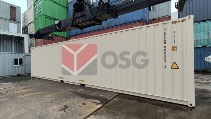 Shipping container in a logistics yard, surrounded by stacks.