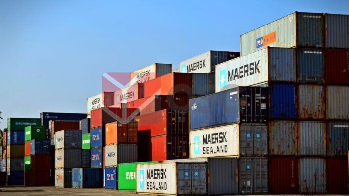 A large stack of colorful shipping containers in a yard.