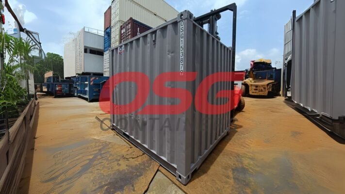 Shipping containers are stacked and moved by forklifts.