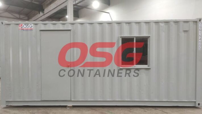 A grey shipping container with a door and window.