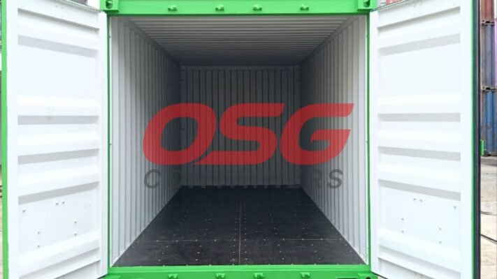 Empty green shipping container with doors open, showing interior.